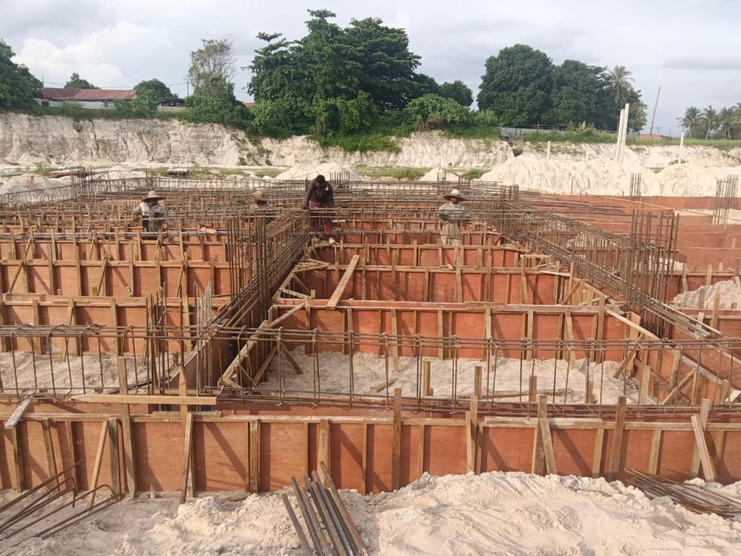 Workers placing rebar at the foundation stage
