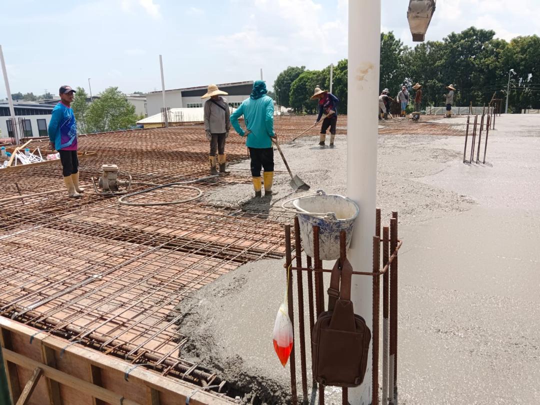 Workers levelling fresh concrete on the slab