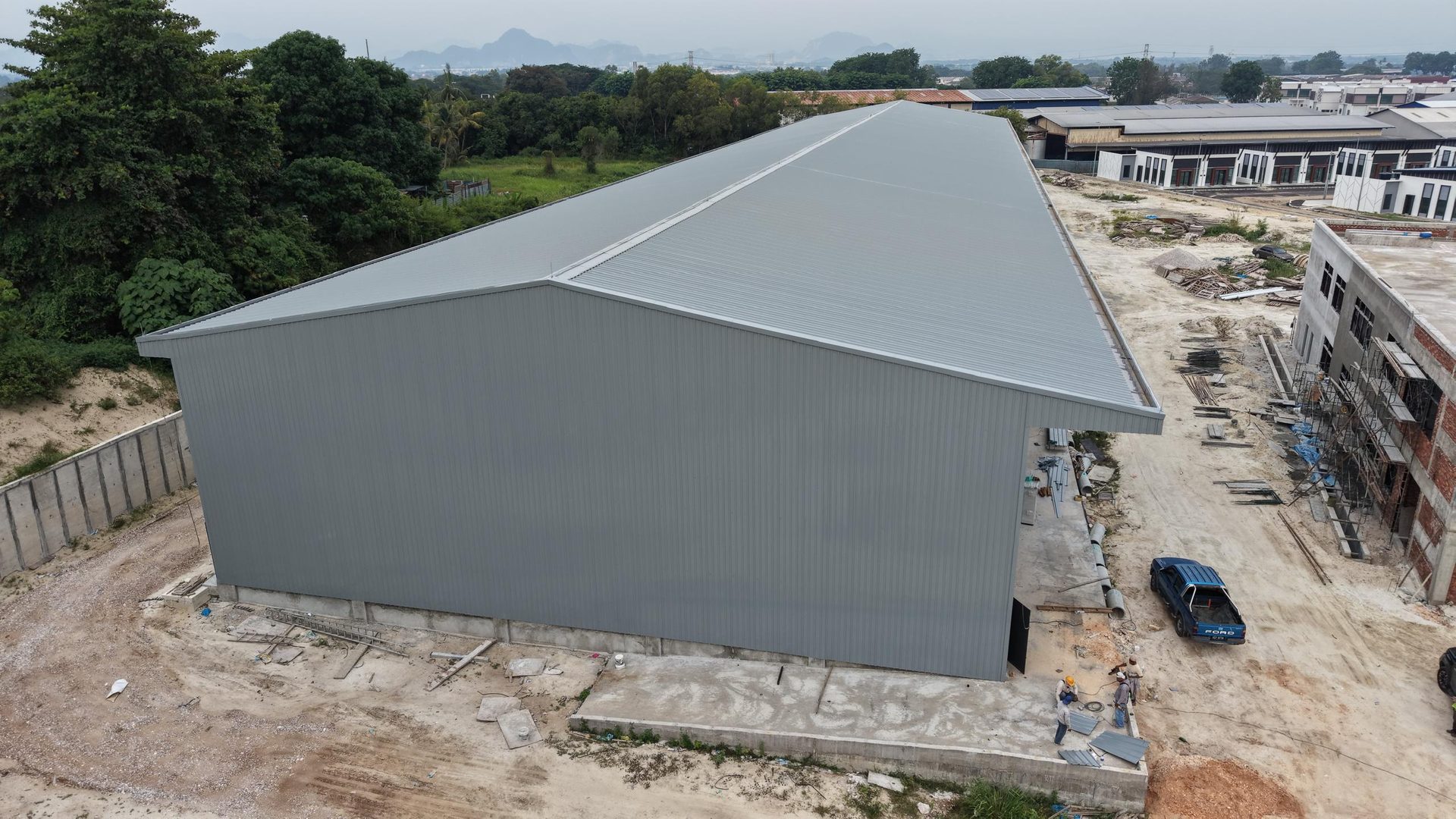 Completed gable end with cladding crew finishing trim work