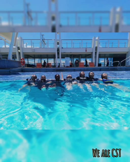 Team floating in a line on the Genting Dream cruise pool