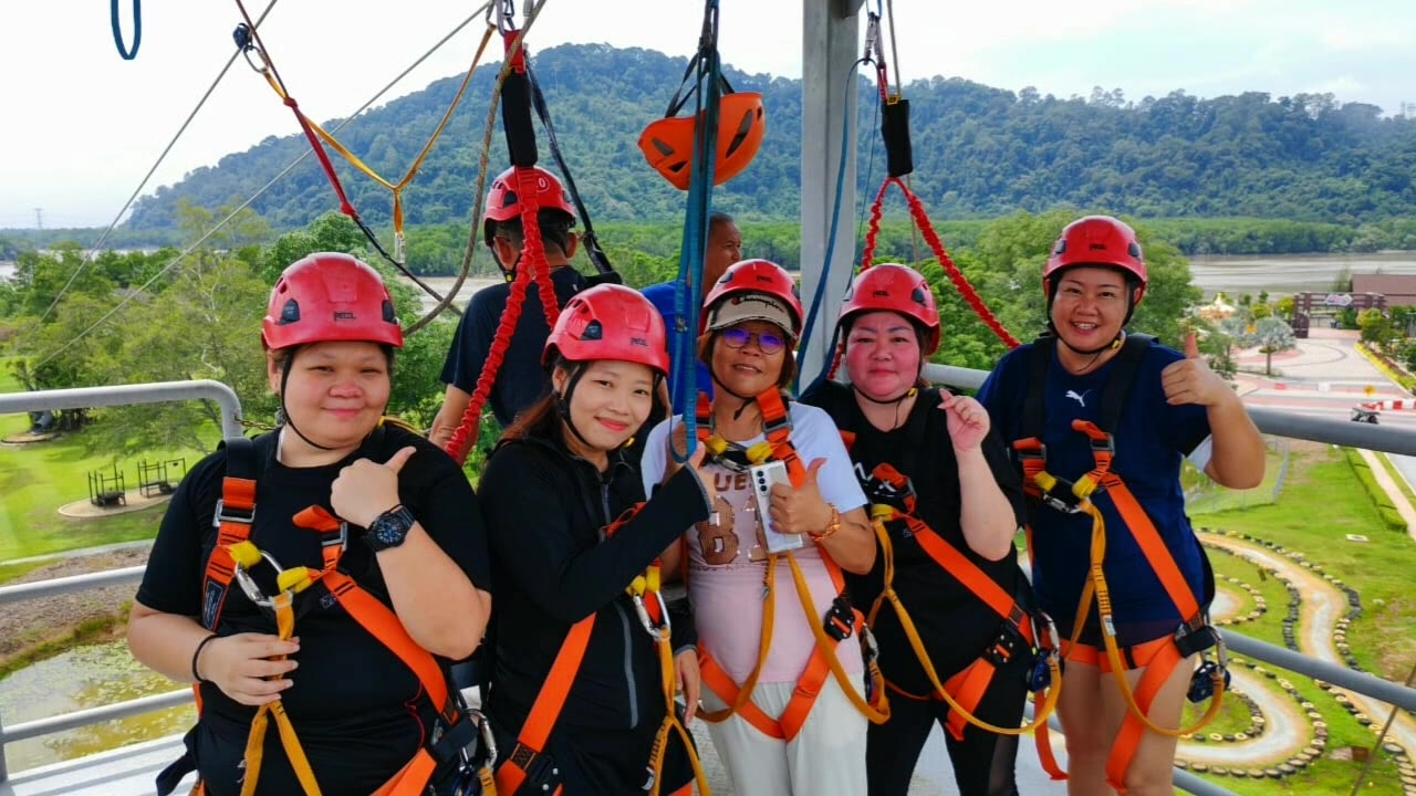 Team on the zipline platform with red helmets and orange harnesses